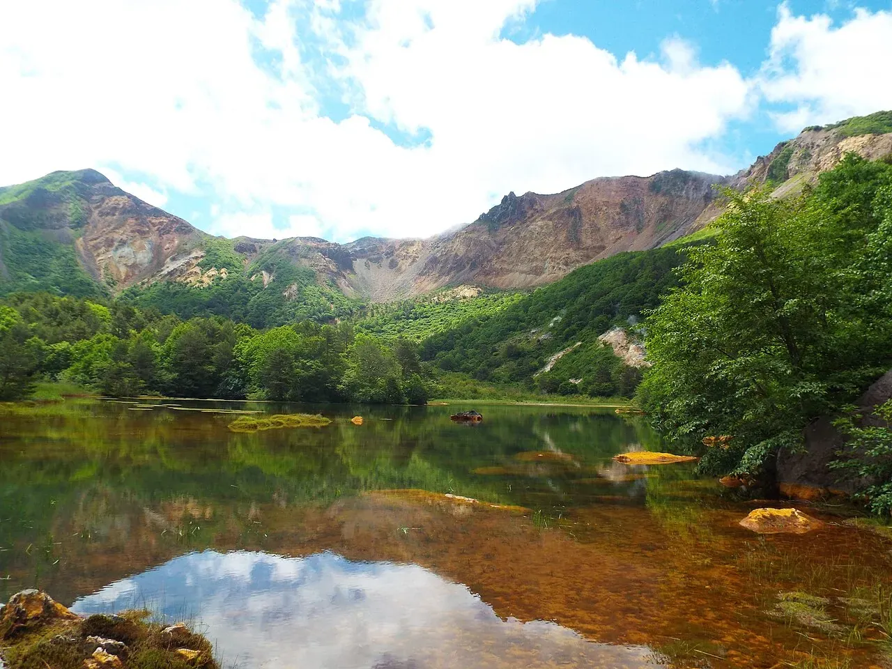 铜沼（赤沼）池塘后面是磐梯山崩塌形成的马蹄形火山口壁