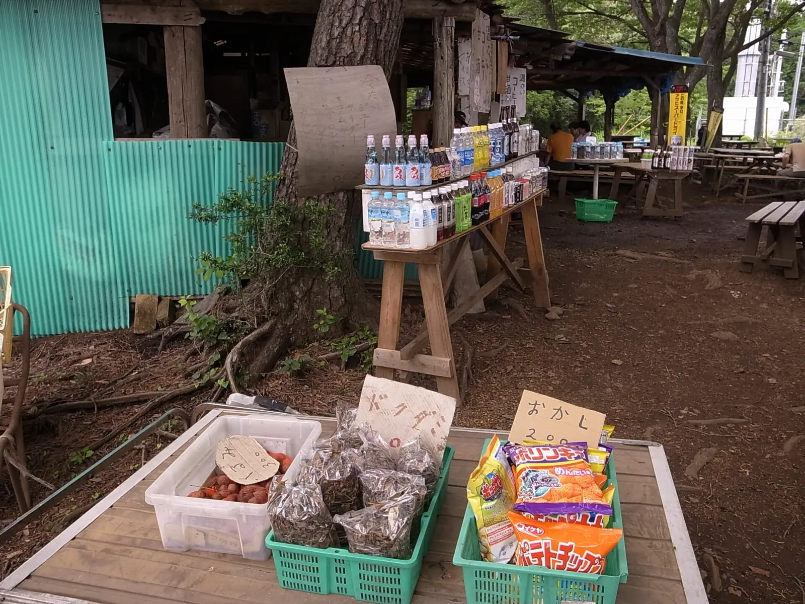 山の茶屋の店先。飲み物や軽食の看板が並んでいる