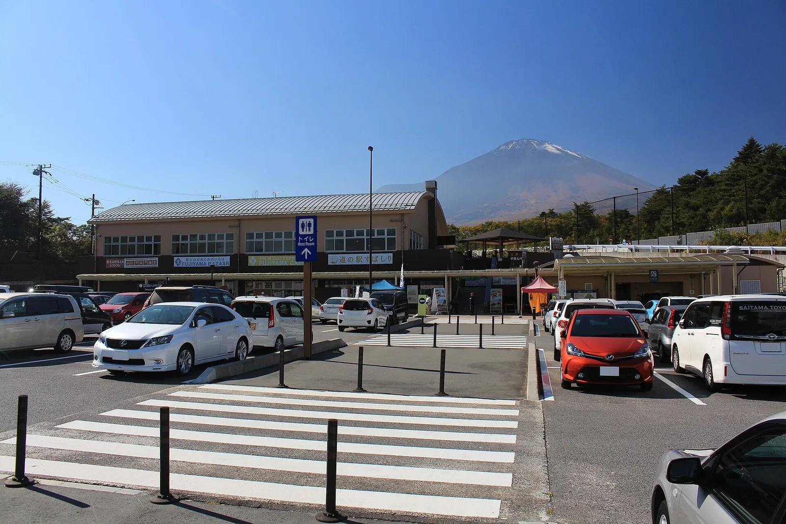 道の駅すばしりの建物と駐車場の向こうに、山頂付近が白くなった富士山