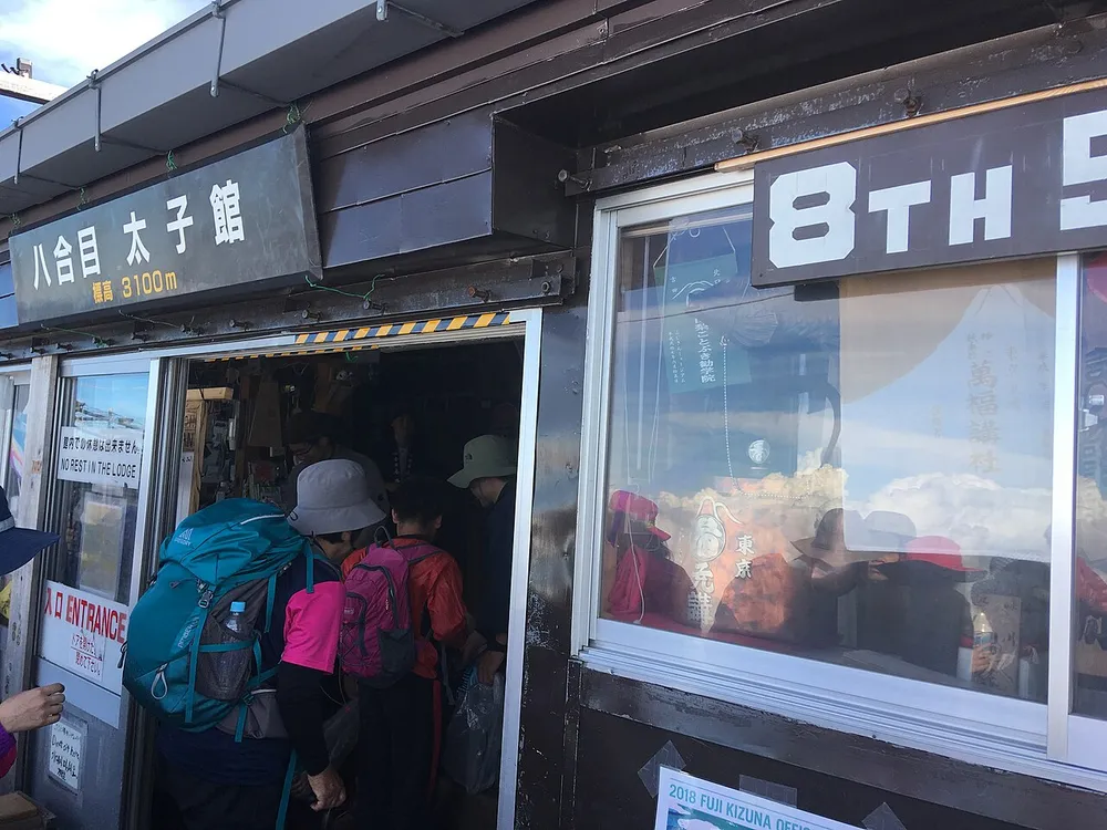 吉田ルート八合目の山小屋の入口に入る登山者