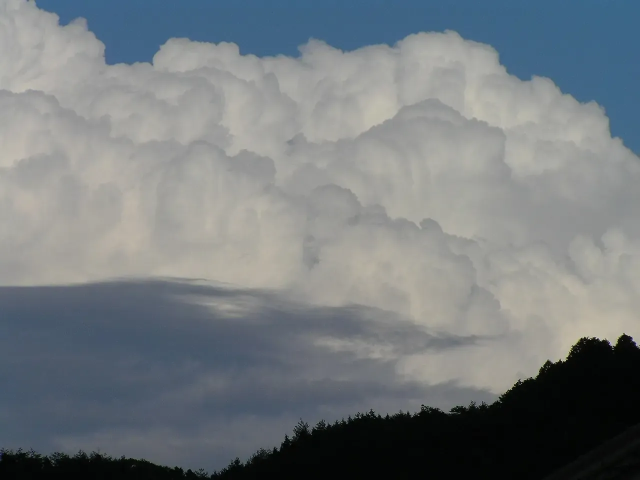 山の稜線の上空に、もくもくと大きく発達した積乱雲