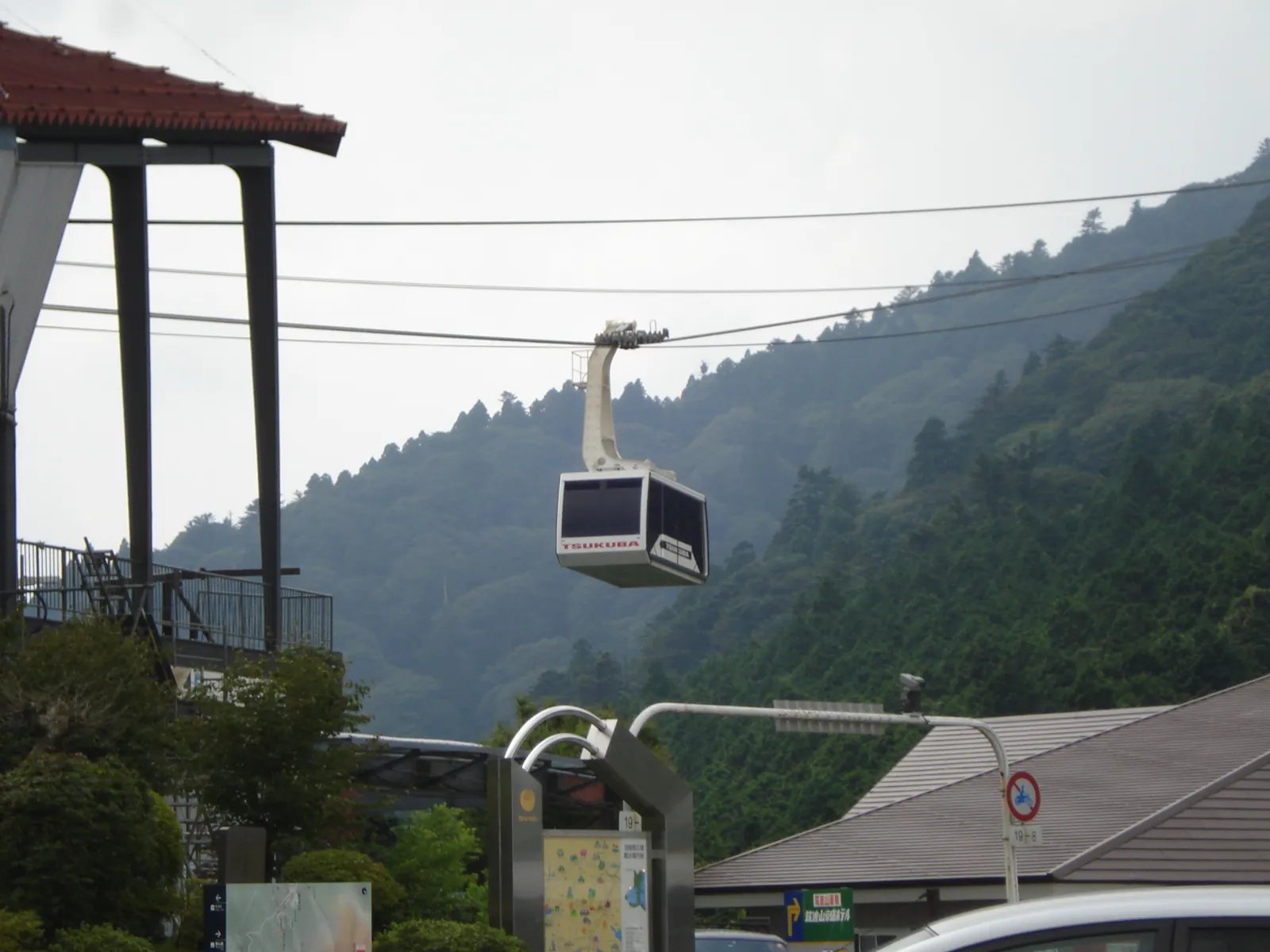 A Mt. Tsukuba Ropeway gondola suspended on cables above the forested slope