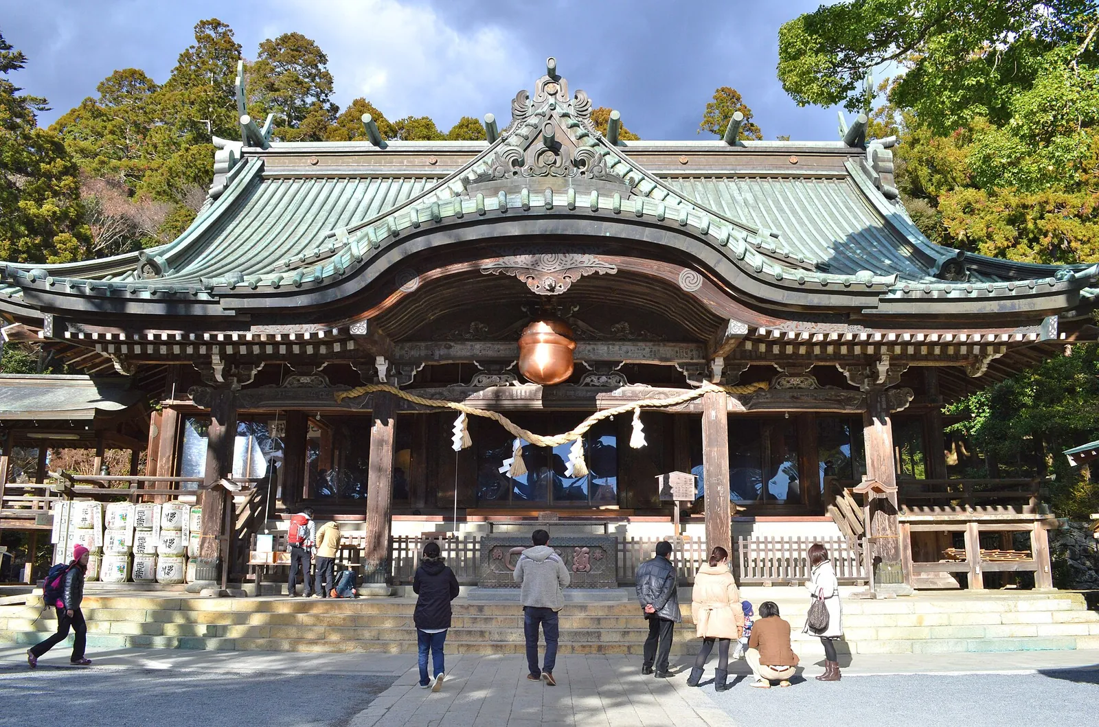 The haiden worship hall of Tsukubasan Shrine with visitors on the stone steps in front