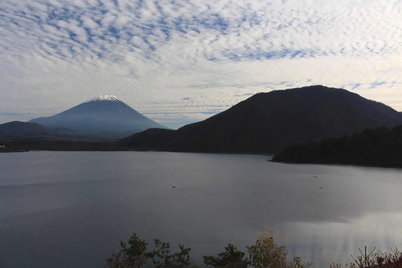 本栖湖の湖面の向こうに並ぶ富士山と竜ヶ岳