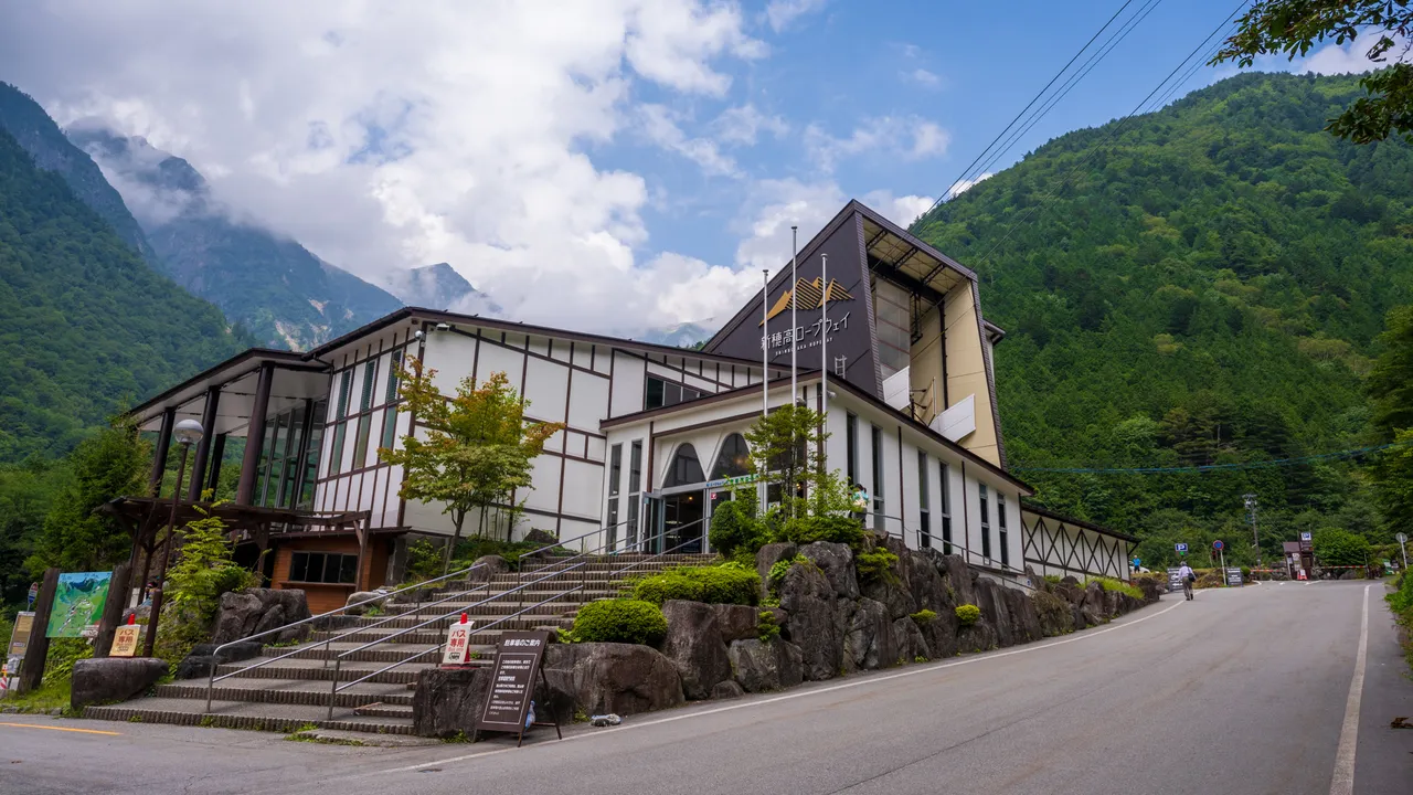山脚的新穗高温泉站站舍，背后是被树林覆盖的山谷