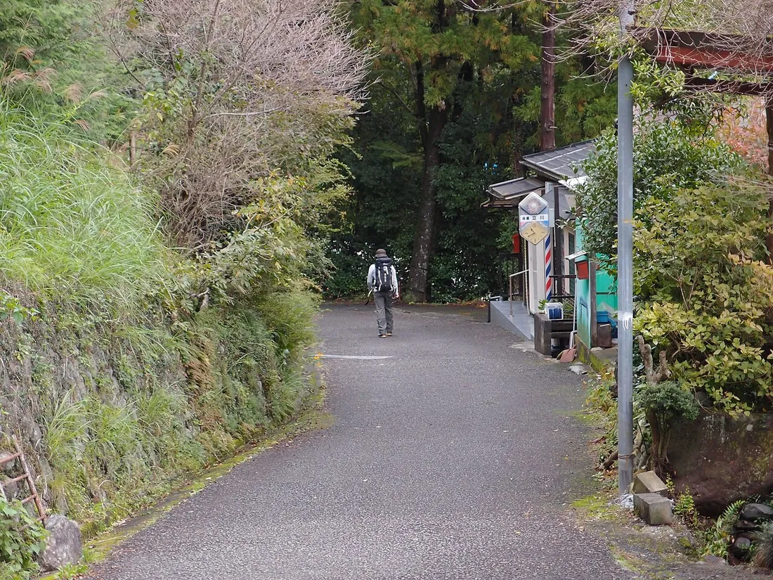 軍畑駅近くの道を歩くハイカー