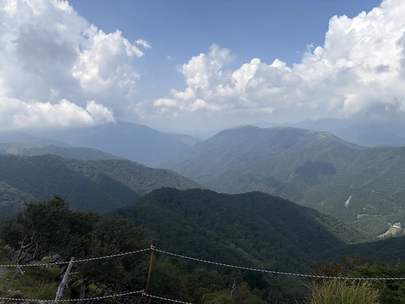 大剣神社付近の登山道から見渡す、緑深い四国山地の幾重にも重なる山並みと白い夏雲